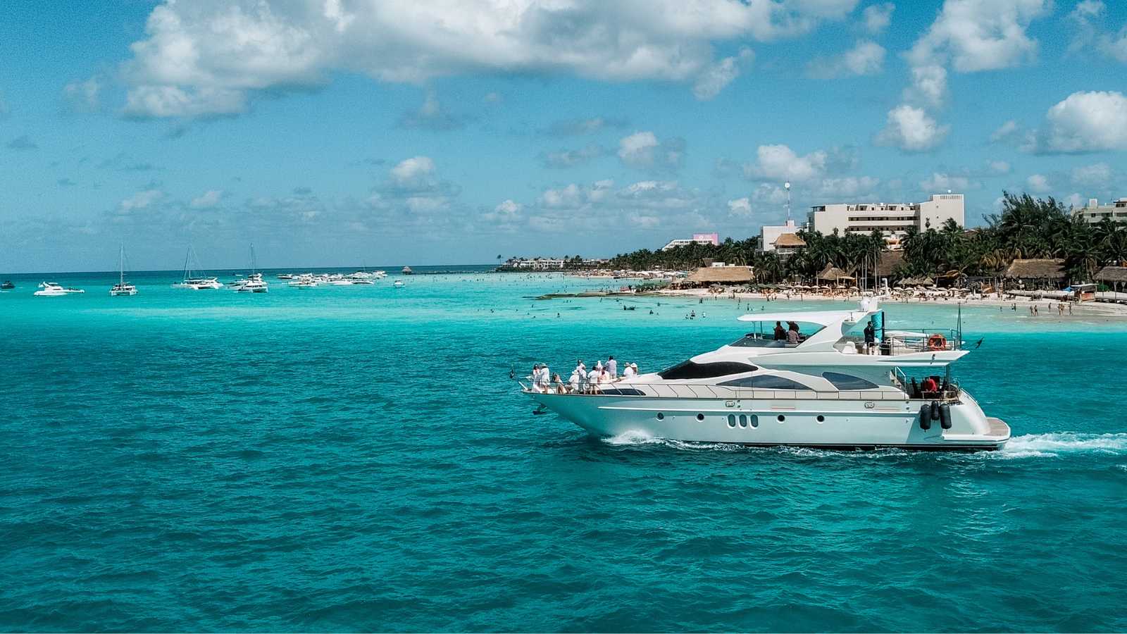 Private yacht cruising beside Isla Mujeres in turquoise Caribbean water