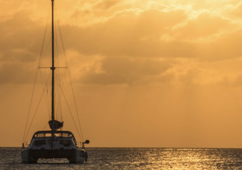 Private catamaran sailing at sunset in Cancun Caribbean Sea